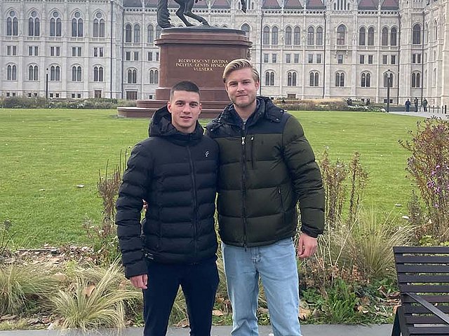 Die Rieker Auszubildenden Philipp und Marian vor historischen Gebäuden in Budapest.