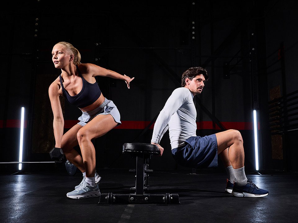 A woman and a man doing their workout in a gym.
