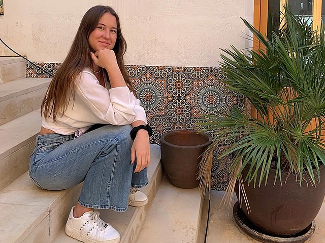 Franzi sitzt auf einer Treppe während eines Fotoshootings in Spanien.