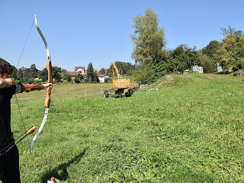 Ein Bagger auf einer Wiese dient als Ziel im Parcour.