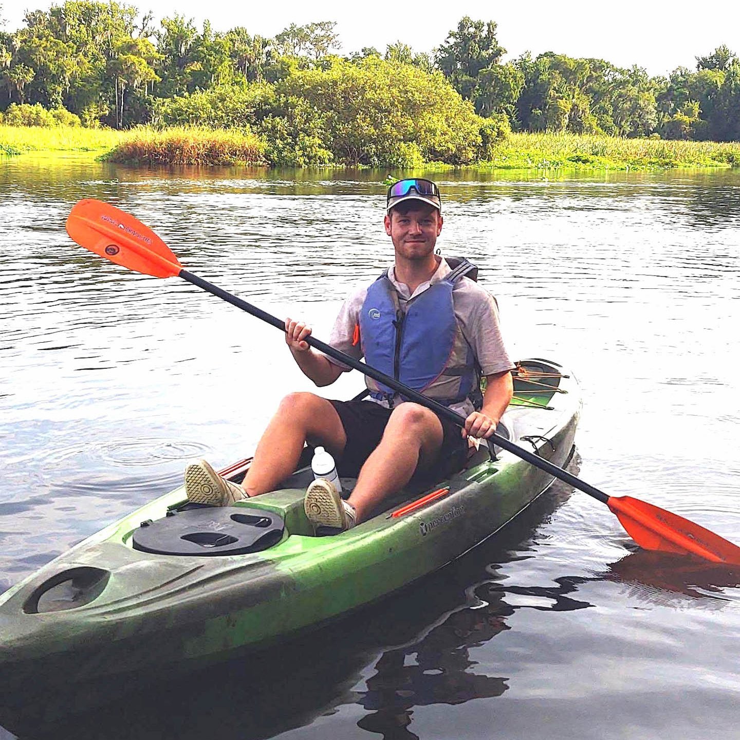 Der Auszubildende Simon der Firma Rieker sitzt in einem Kayak und fährt über einen Fluss.