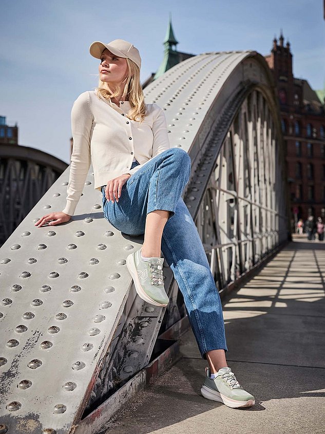 Frau in der Stadt mit Alltagsoutfit und Rieker Sport Schuhen