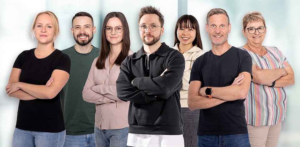 Mitarbeiterinnen und Mitarbeiter unterschiedlicher Abteilungen von Rieker lächeln in die Kamera