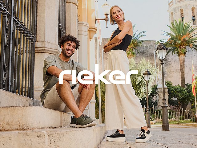 Eine Frau und ein Mann tragen frühlingshafte Alltagsoutfits mit Sneakern und befinden sich in einer mediterranen Stadt. Mittig im Vordergrund ist das Rieker Comfort & Style grafisch platziert.