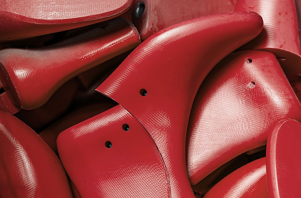 Red shoe lasts are used in shoe production at Rieker.