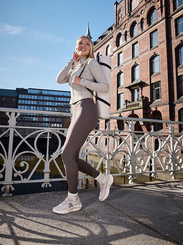 Frau in der Stadt mit Sport Sachen und Rieker Schuhen