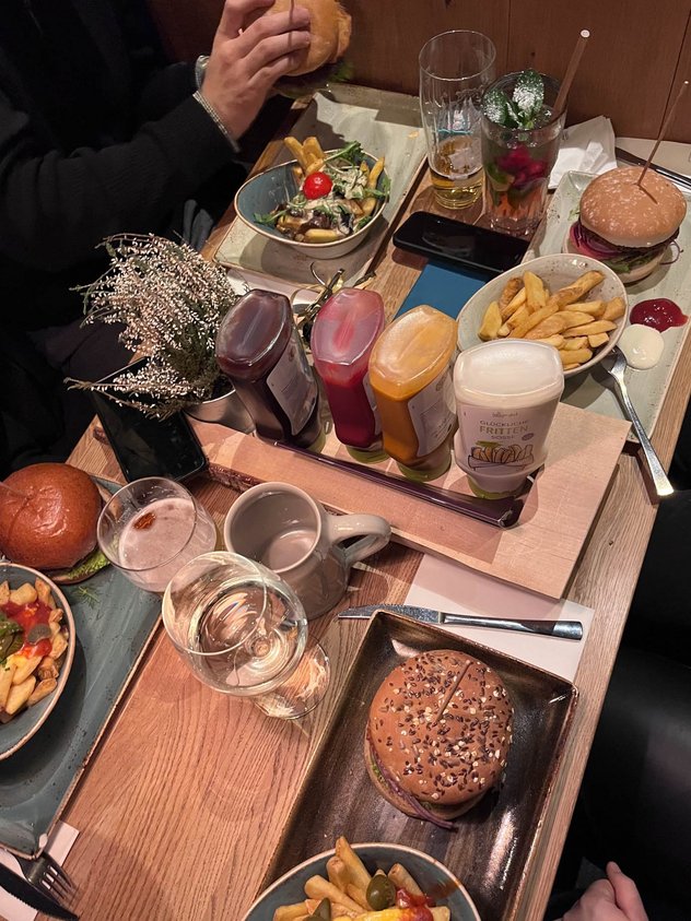 Ein gedeckter Tisch mit Burger und Pommes.