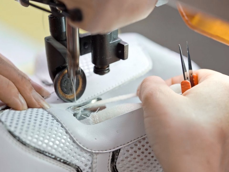 Ein remonte Schuh wird von Hand mit einer Nähmaschine produziert.
