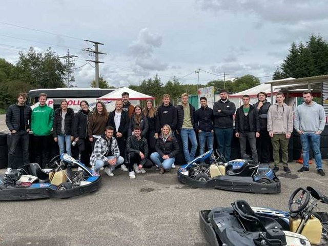 Gruppe von Rieker Auszubildenden posieren auf einer Kartbahn.