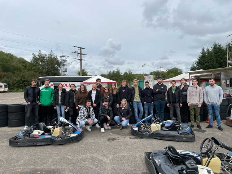 Gruppe von Rieker Auszubildende posieren vor Gokarts. 