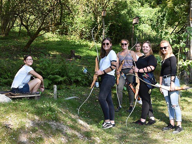 Gruppenaufnahme von Azubis von Rieker beim Bogenschießen im Rahmen des Azubiausflugs.