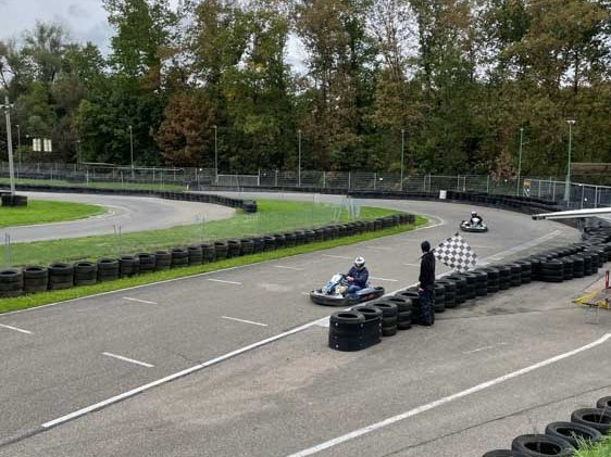 Auszubildende von Rieker fahren mit Gokarts über die Rennstrecke.