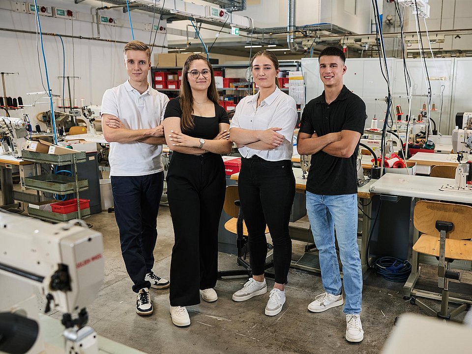 Auszubildende der Ausbildung zum Schuhfertiger stehen in der Produktionshalle